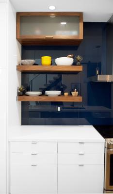 Photo of the Berkeley bungalow kitchen with white lower cabinets with open and closed wooden shelves on a dark navy tiled wall