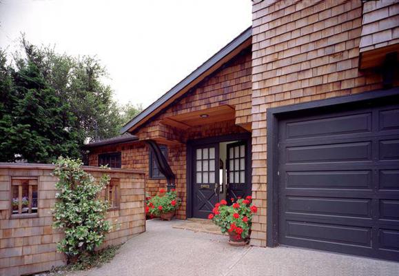 Front entryway with wood shingled sides and dark brown trim and matching garage. From Facade Renovation in Piedmont, California designed by Susan L. Wootan