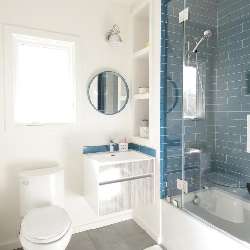 The Berkeley bungalow upstairs bathroom features a hanging vanity and a blue tiled bath and shower area