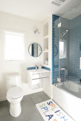 The Berkeley bungalow upstairs bathroom features a hanging vanity and a blue tiled bath and shower area
