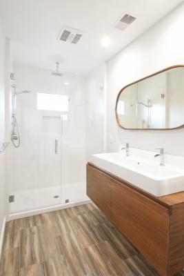 The Berkeley bungalow master bath is bright and warm with white tiles and fixtures warmed up with wood floors and vanity